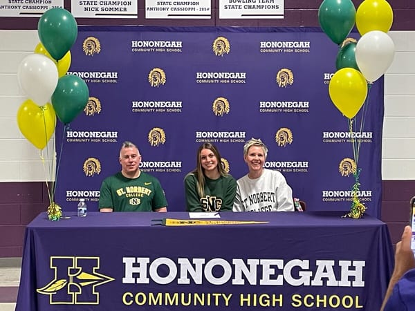 Roscoe, IL Senior Gracie Wolfe signs a Letter of Intent with St Norbert College surrounded by parents, coaches, and friends.