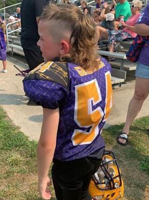 Boy in a football uniform and a mullet hairstyle