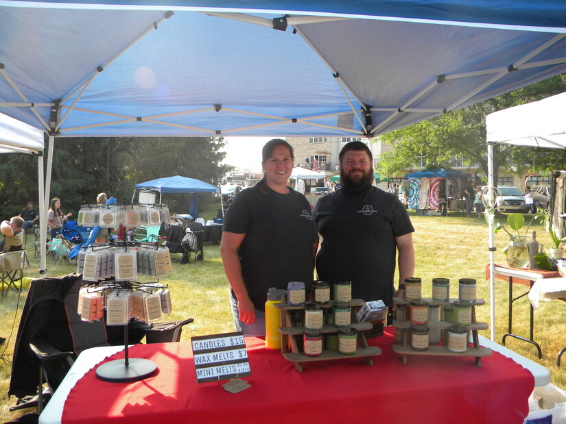 Vendors stand under tent for candle business