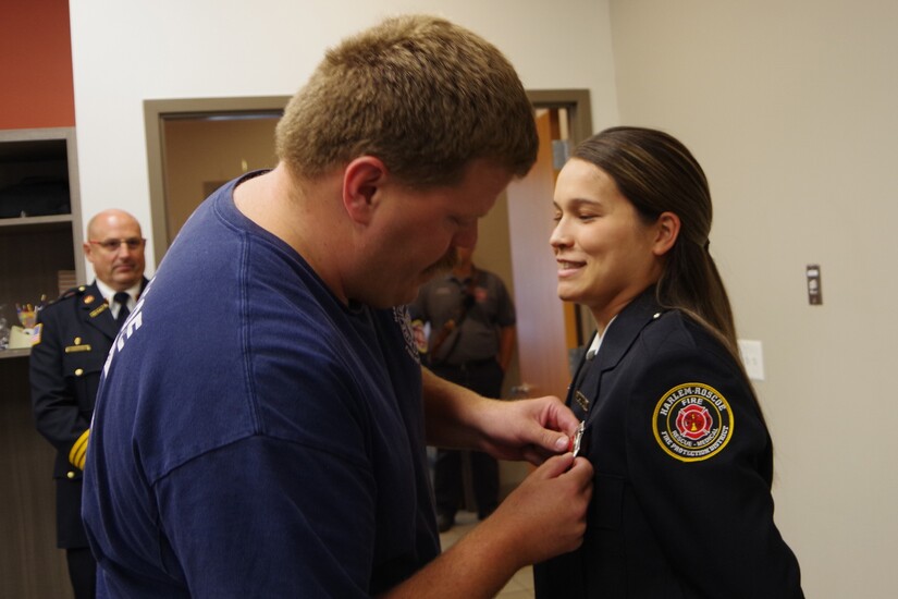 Man pins fire lieutenant pin on female fire department officer