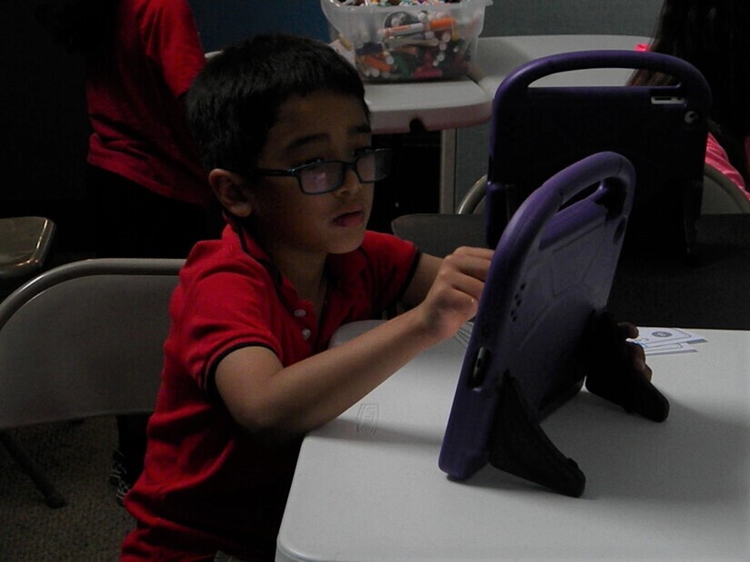 child coding on a tablet