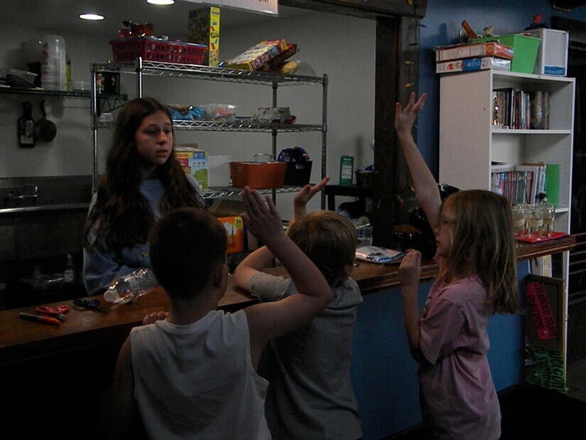 kids choosing snacks from the snack bar with hands raised