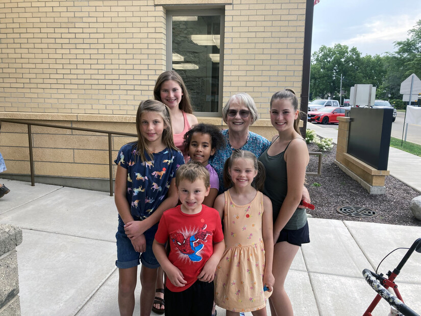 Grandma and grandkids pose outside public library