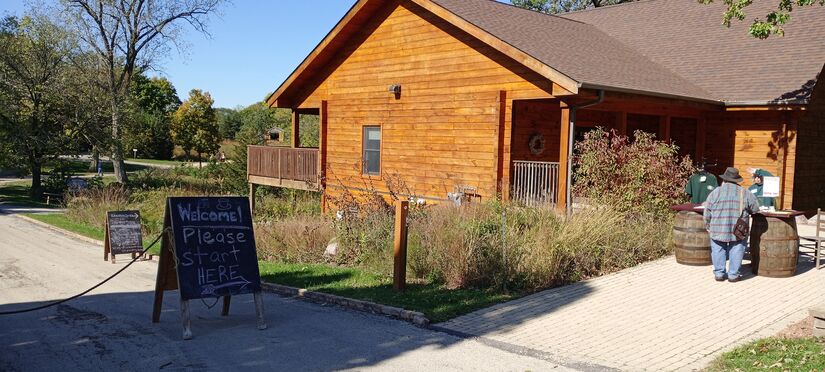 modern wooden visitors center with sign "Welcome! Please Start Here"