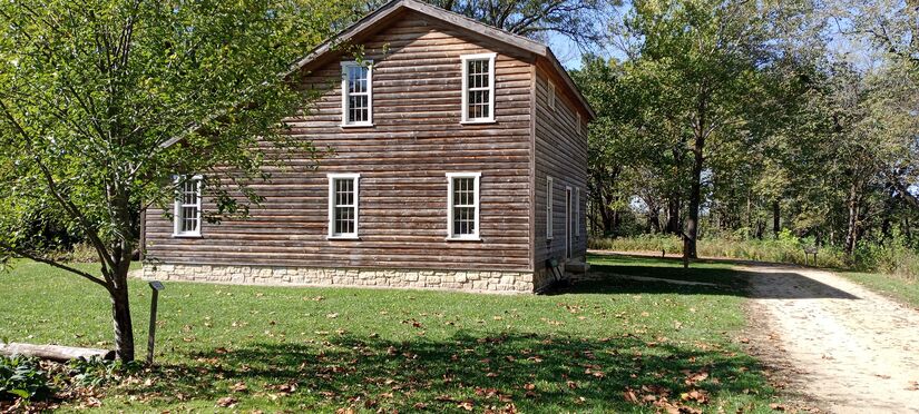 wooden building with sloping roof on left, from 1840s, at Macktown Living History, Rockton IL