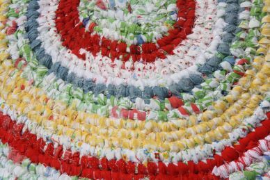 Toothbrush rag rug, made of circular rings of red, white, yellow, green, and blue rags