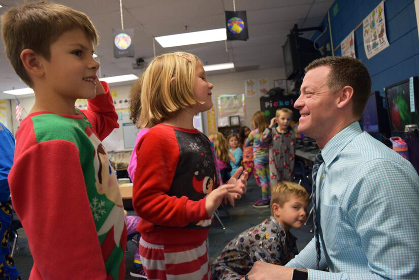 children talking with smiling school principal